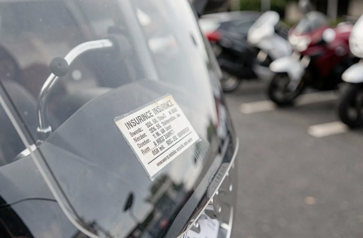 Gros plan sur un autocollant d'assurance moto collé sur le pare-brise d'une moto