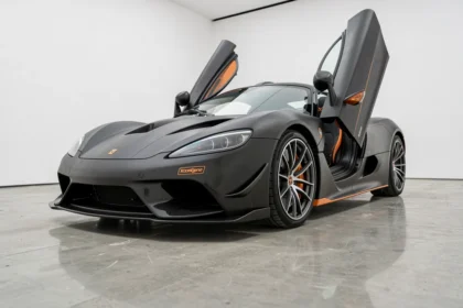 Koenigsegg Agera R en carbone noir mat exposée dans un showroom blanc épuré avec reflets au sol